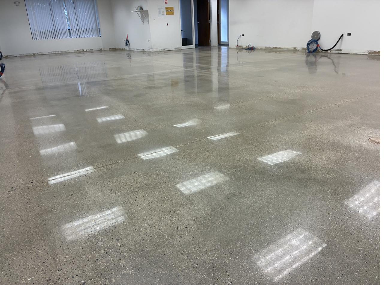 Close up of polished concrete office floor reflecting ceiling lights